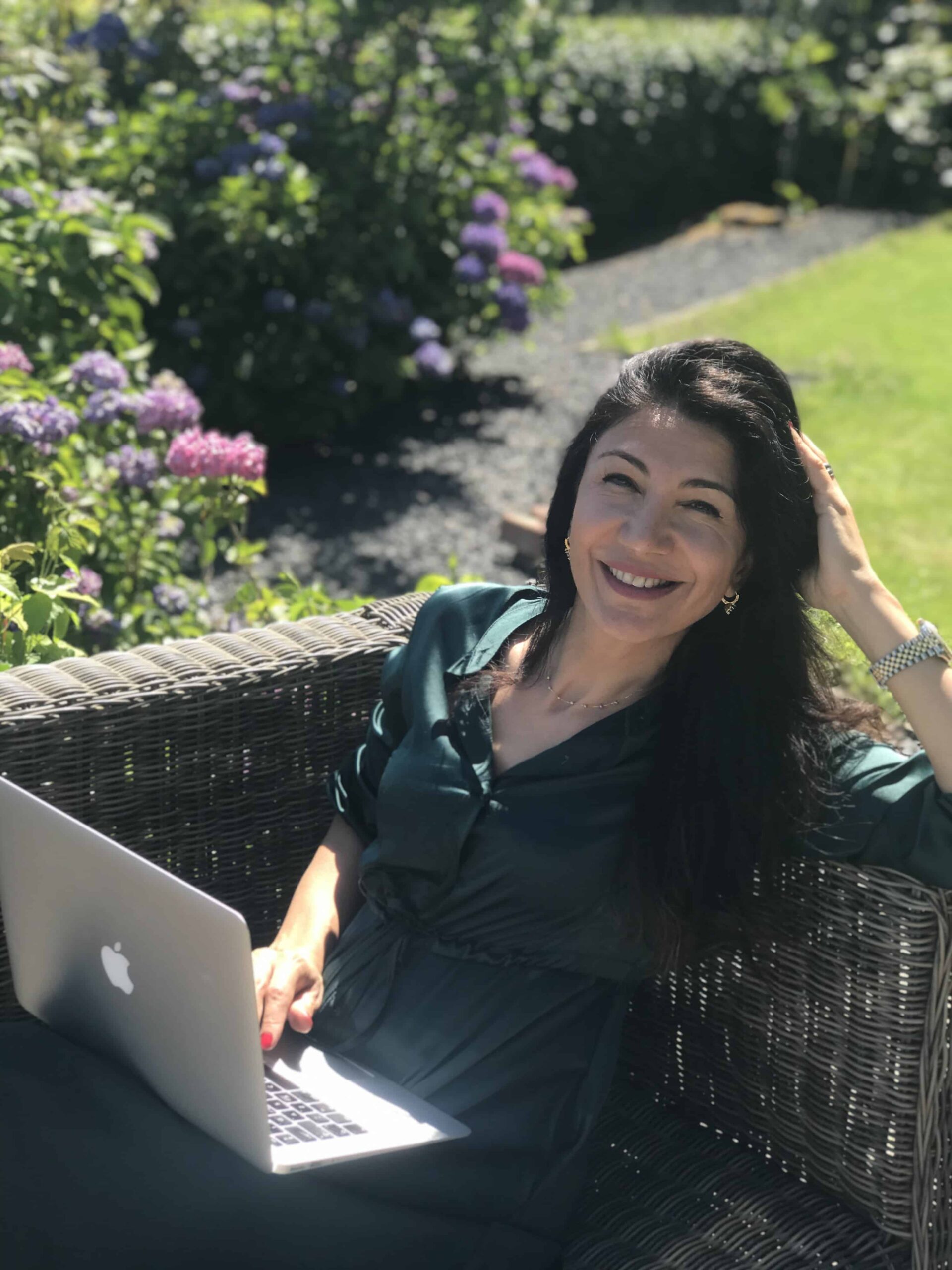 Foto Songul Kinran van Esenzz Loopbaancoaching werkend in de tuin aan haar online masterclass